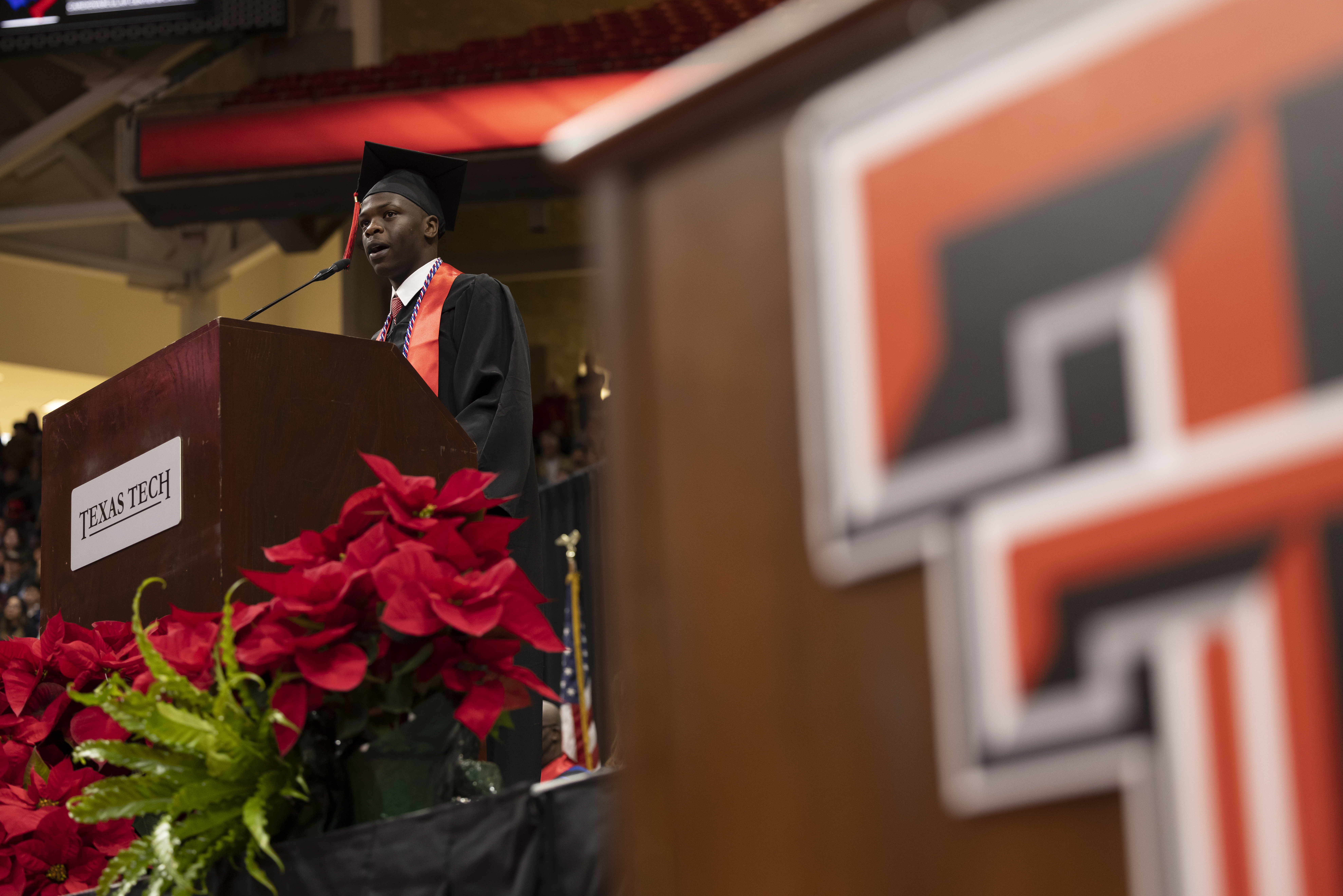 Person in graduate cap and gown at podium