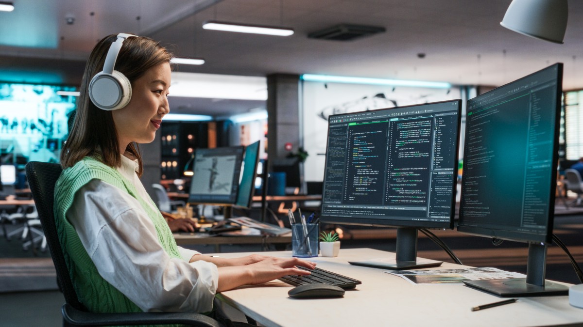 Woman with headphones looking at a computer