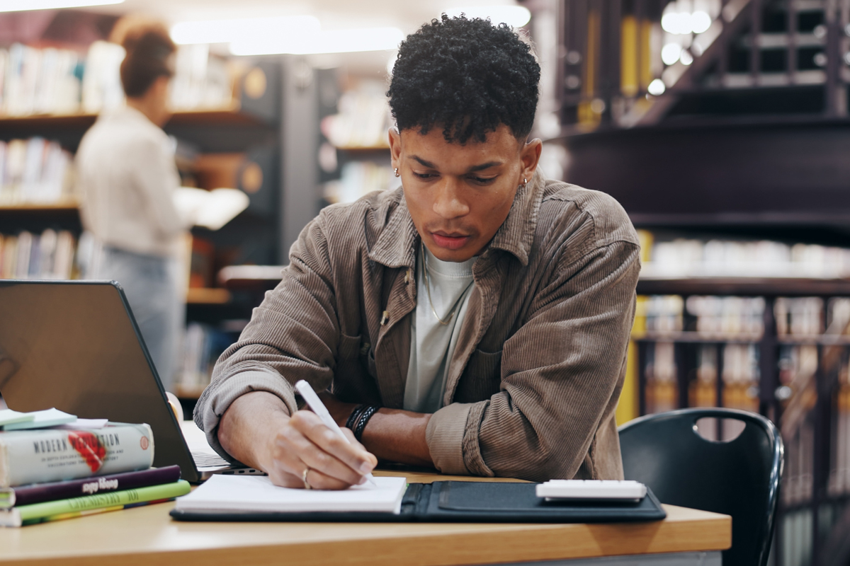 Male person, laptop and reading for education knowledge, history exam and project planning