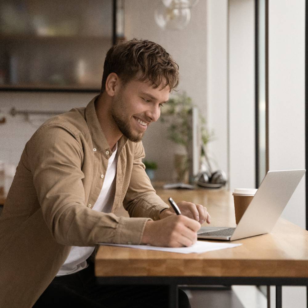 Person taking notes with a laptop