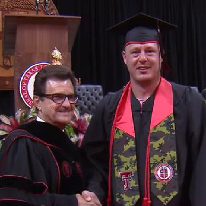 Photo of Greg Dotson shaking hands with President Lawrence Schovanec at graduation