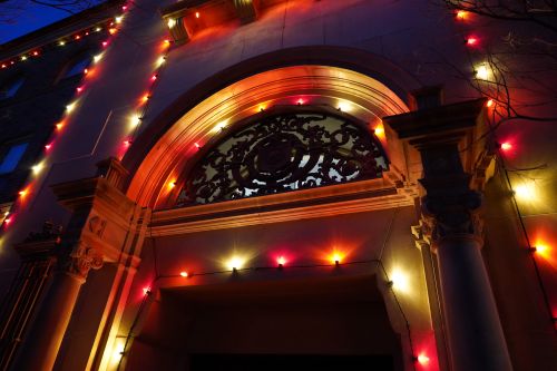 Night image of christmas lights hanging over a doorway