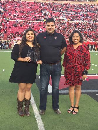 Parents of the Year awarded plaque during the Family Weekend football game