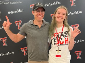 Photo of a father and daughter attending Red Raider Orientation with their guns up