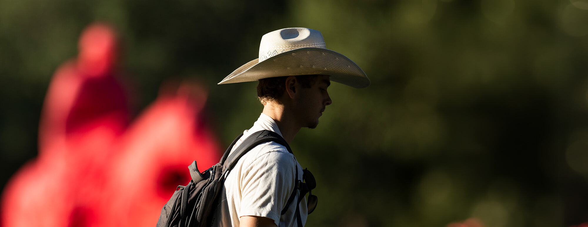 student white cowboy hat talking on Texas Tech University campus