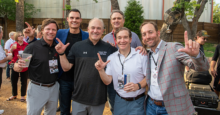 Group alumni doing guns sign