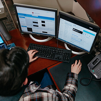 Guy in Front of Computer Adding Dates on Calendar