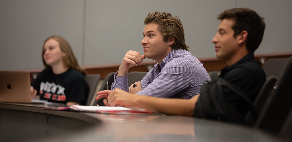 Three students paying attention in classroom