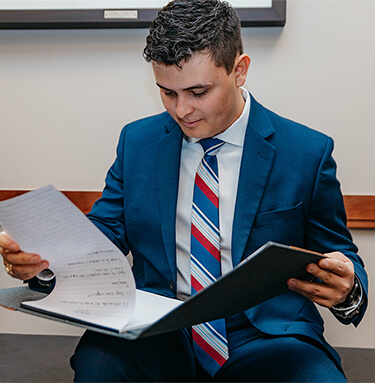 Man in Suit Reviewing Folder with Notes