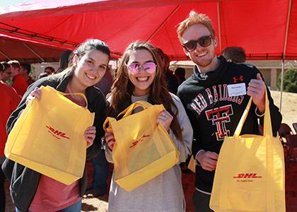 Rawls students show their DHL goodie bags at the tree-planting event.