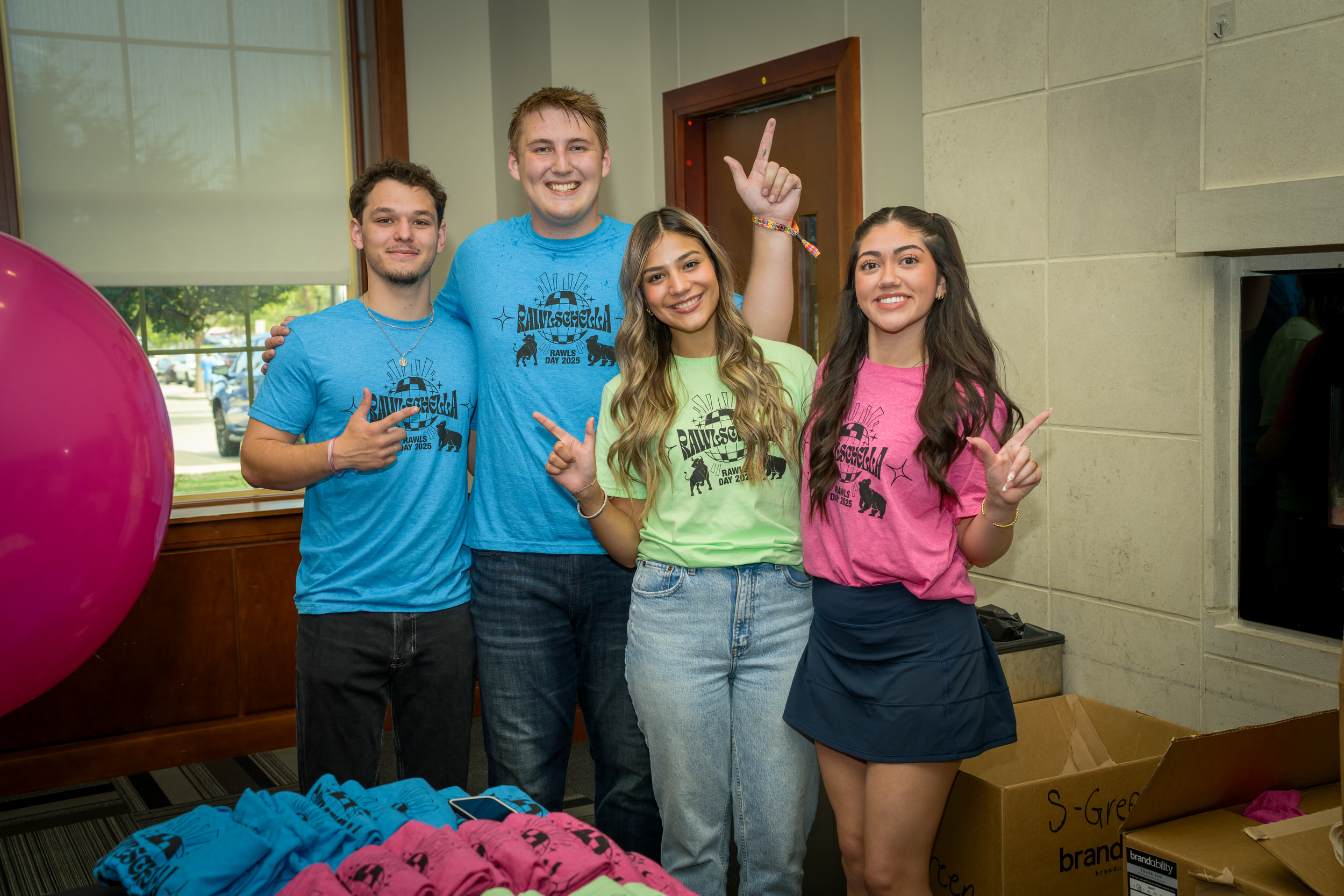 Students posing in their various colored Rawls Day t-shirts.