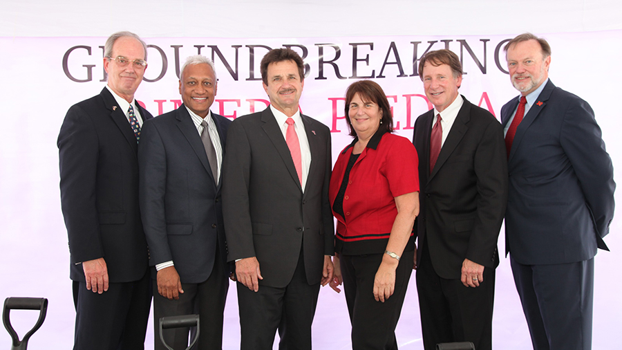 administrators in front of groundbreaking sign