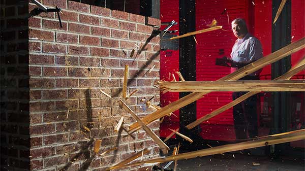 wood splintering from impact against brick wall