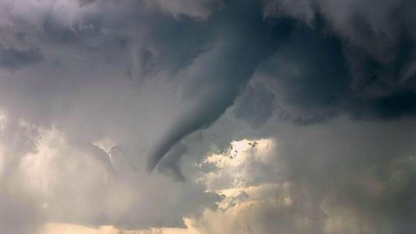 An ominous tornado in a dark, stormy sky.