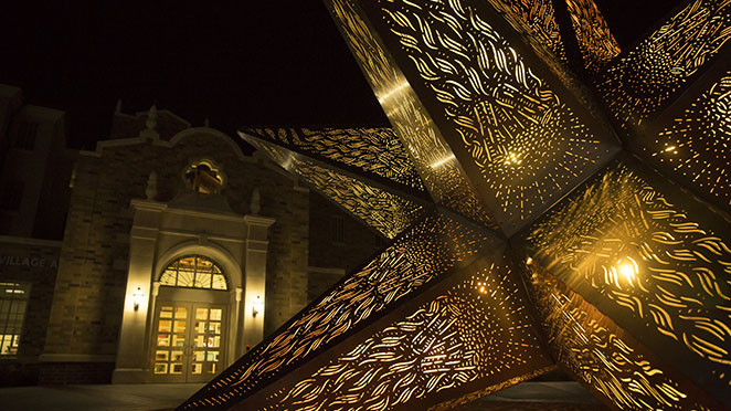 large starburst sculpture lit up at night