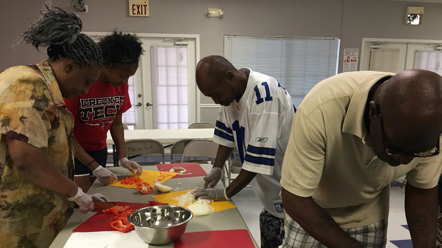 two men and two women chopping peppers and onions at lets cook, eat and talk