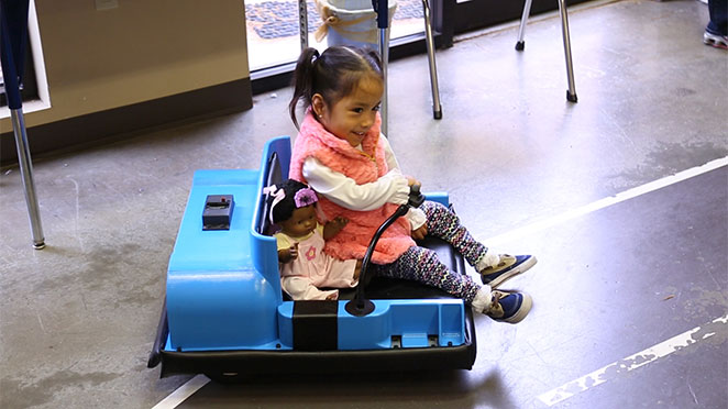 ava and her baby doll on cart