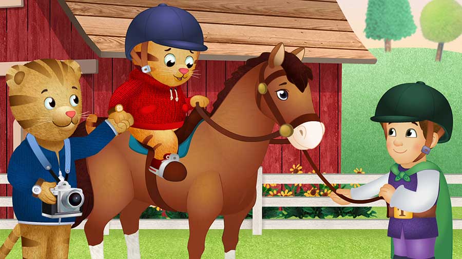 screen cap from episode. daniel tiger sitting on a horse, holding dads hand while horse is held by trainer