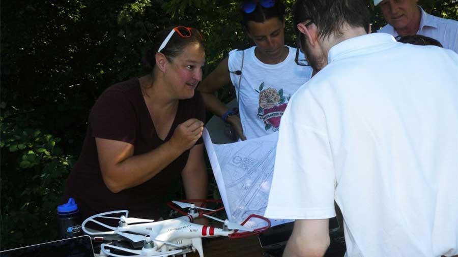 Friedman shows a drawing to resident with drone on table in front of her