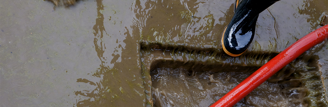 worker pushing water into hole