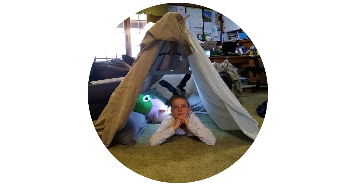 Fort in a Box Founder Daniel Jones looks out from a blanket fort. Photo courtesy: Fort in a Box