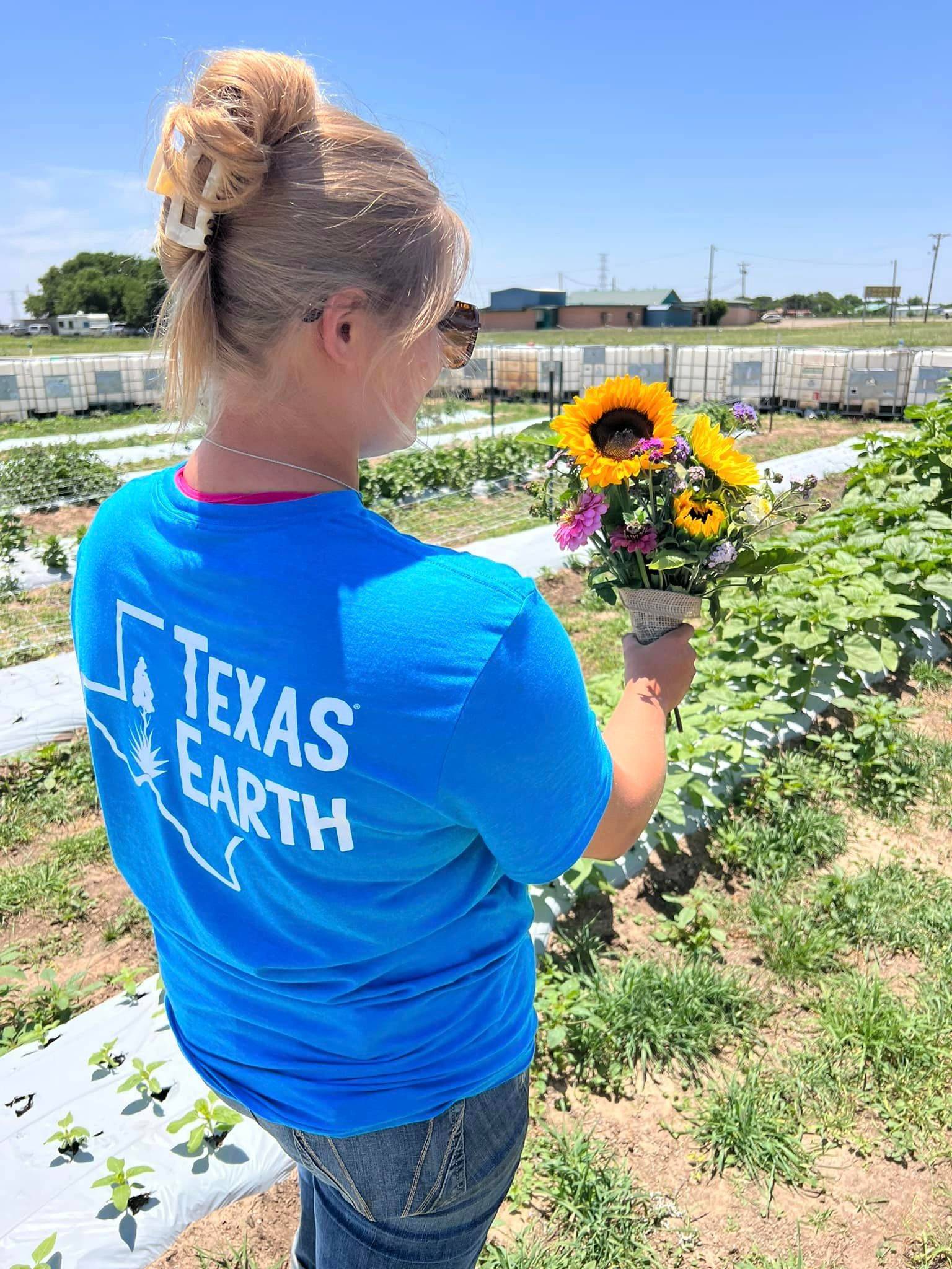 Abigail Oliver holding up flowers at Texas Earth's Patina Flower Farm.