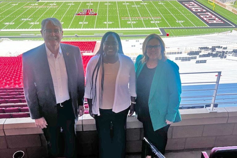 Dr. Joseph Heppert, Stacy Ann Russell and Taysha Williams share smiles at AT&T Stadium.