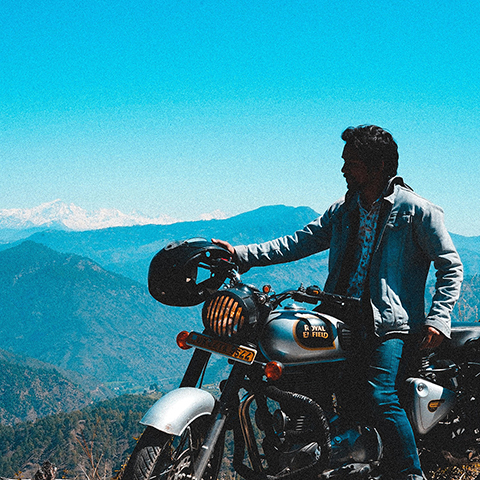 a man on a motorcycle overlooking a valley