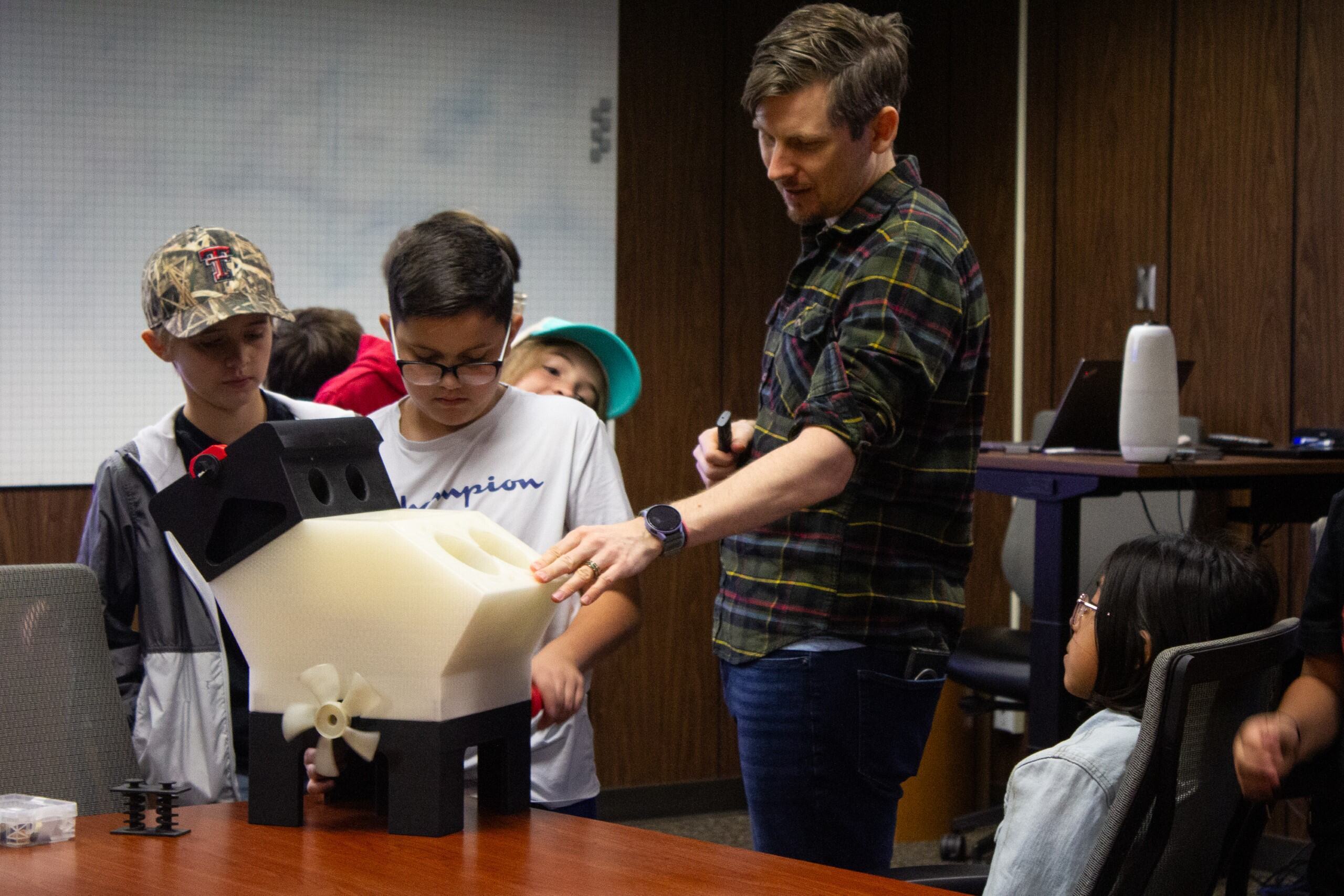 Students looking at engine model