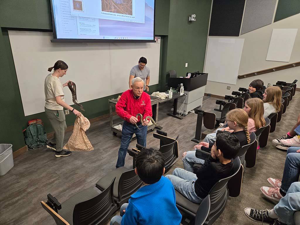 Dr. Densmore showing snake to class