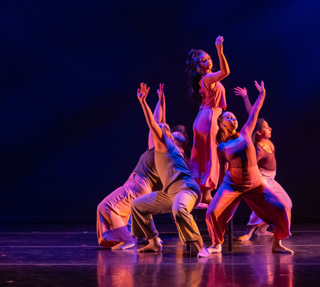 TTU dance students huddled up on stage posing