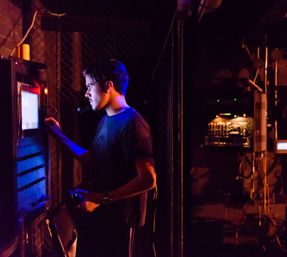 TTU Theatre student working behind the curtain