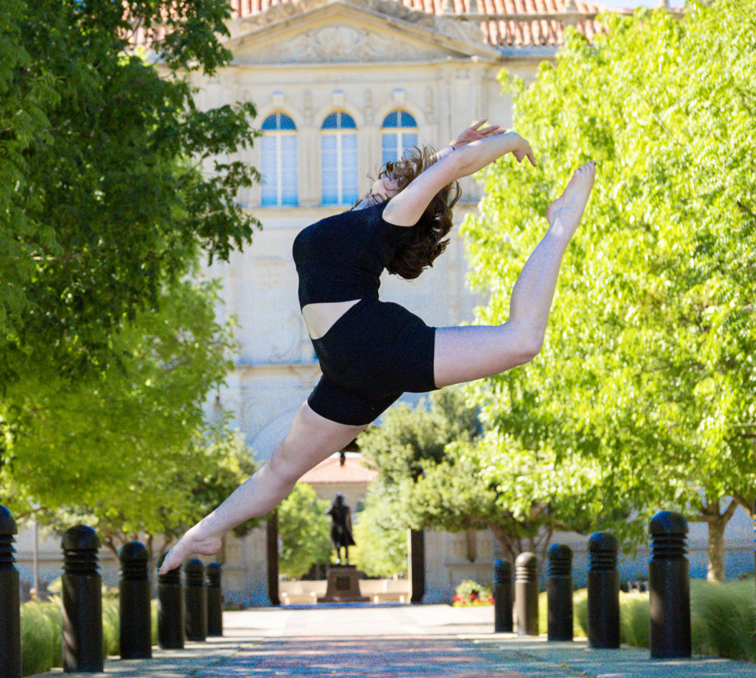 Theatre & Dance student jumping in the air and posing