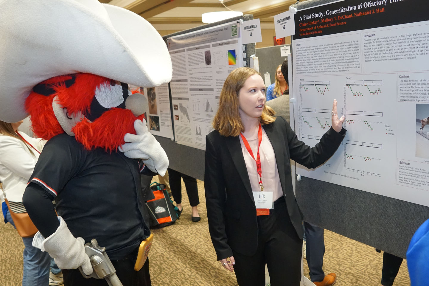 Red Raider looking at a poster at Undergradiate Research Conference at Texas tech University.