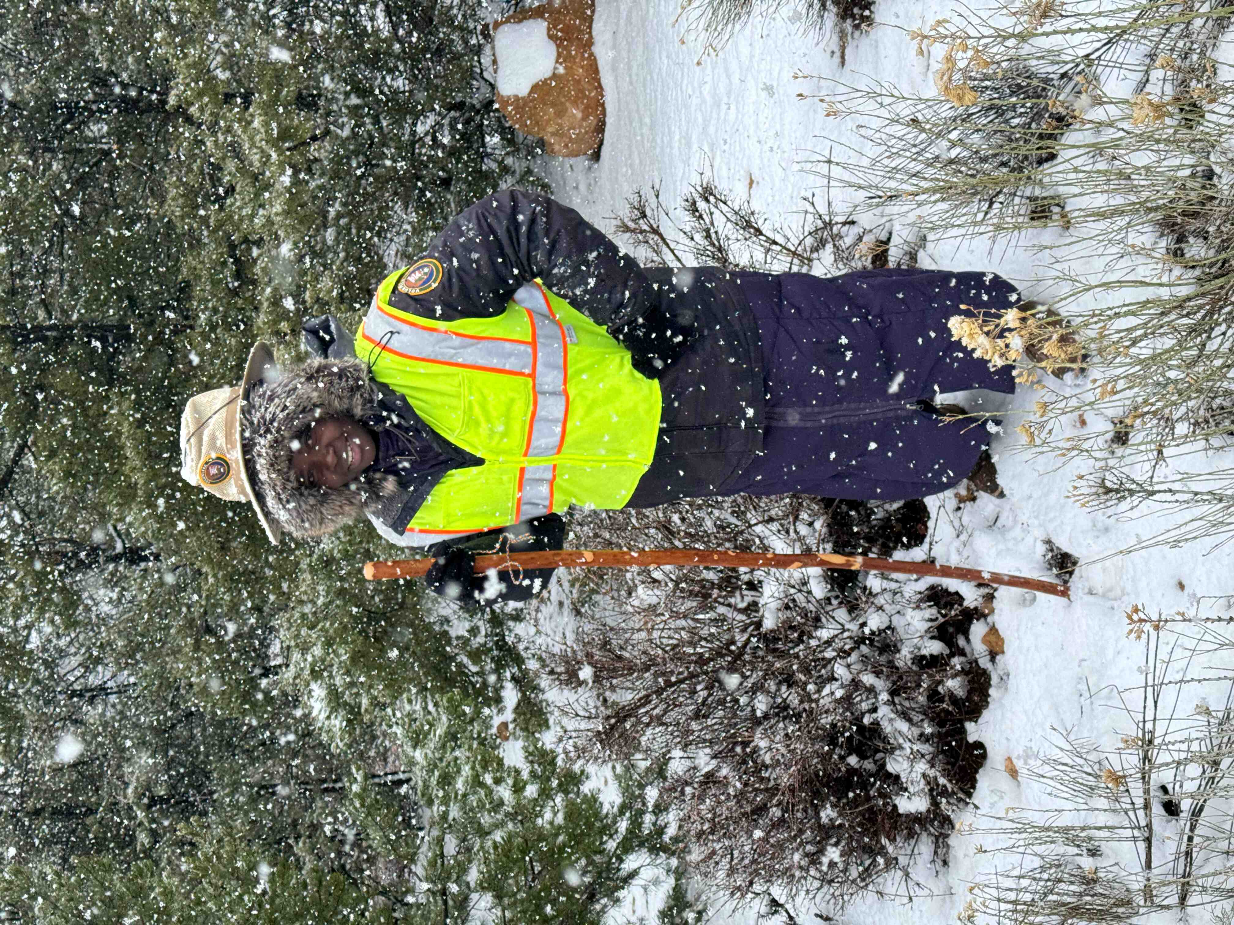 Ynes standing in snow with a stick in hand