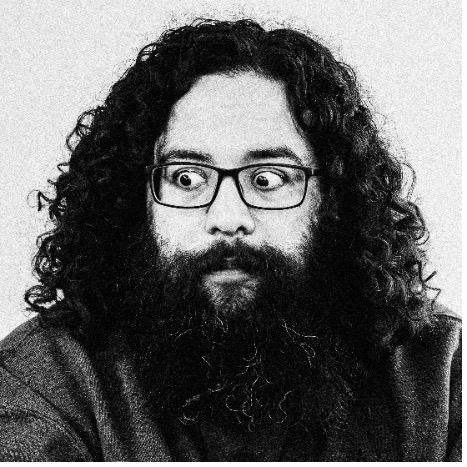 A person with long curly hair and a beard