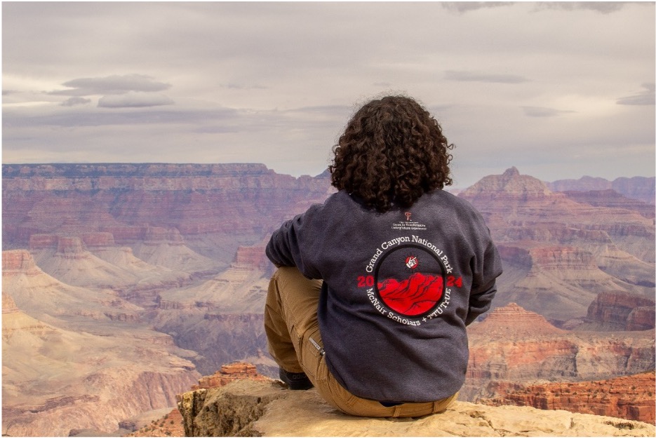 Joe sitting on a rock looking at the canyon