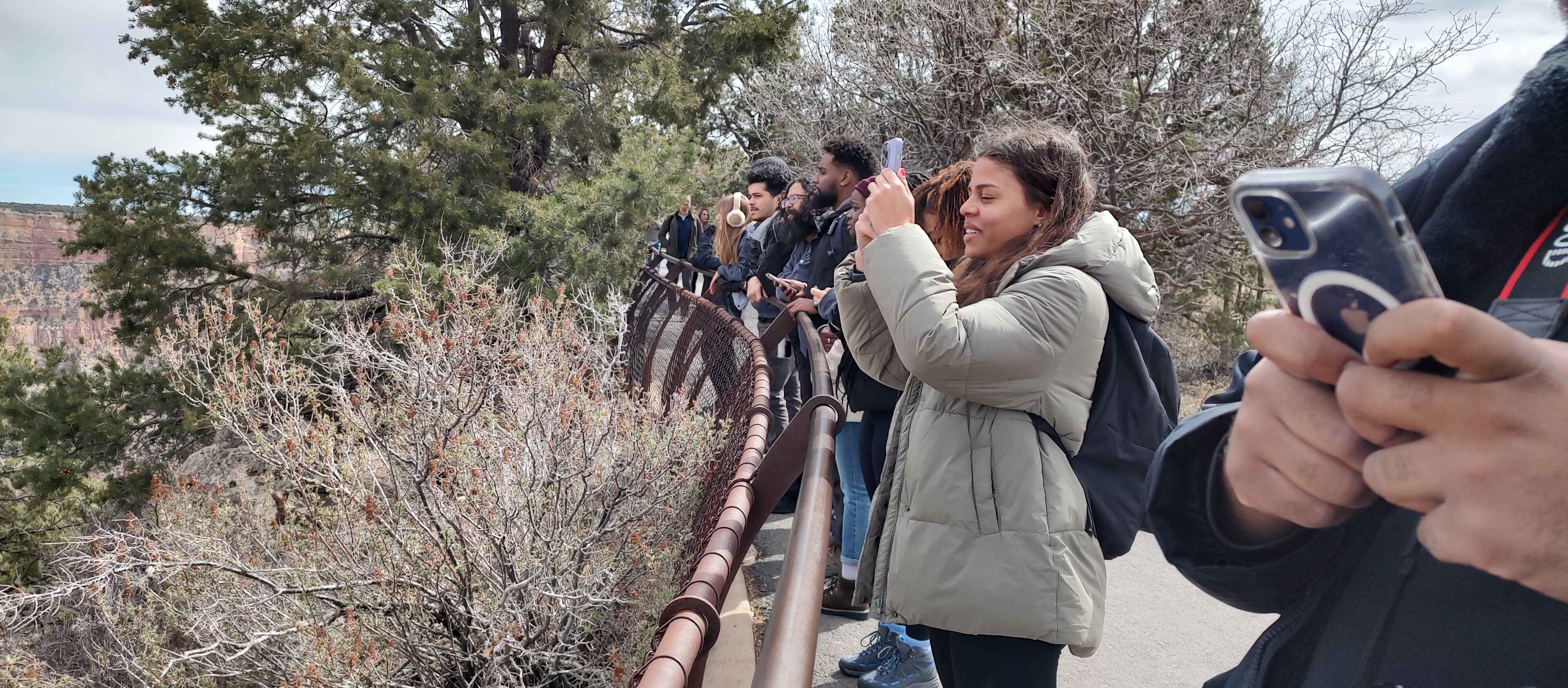 A group of people taking pictures of the Grand Canyon