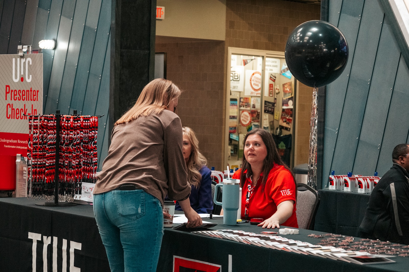 TrUE staff checking in an URC attendee