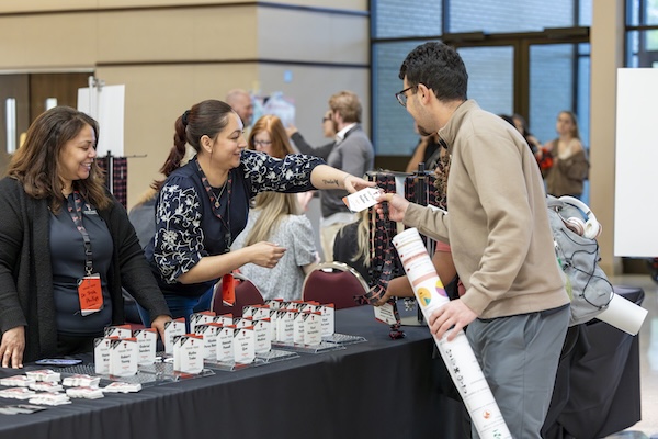 TrUE staff checking in an URC attendee