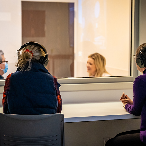 Faculty and staff listening to a student's interaction with client