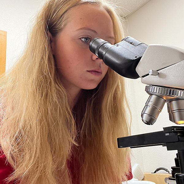 Student looking through microscope