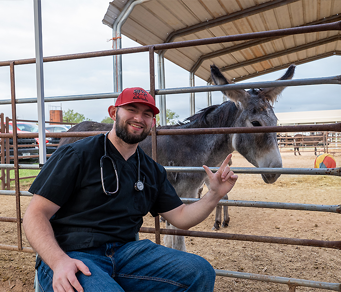 student beside a donkey