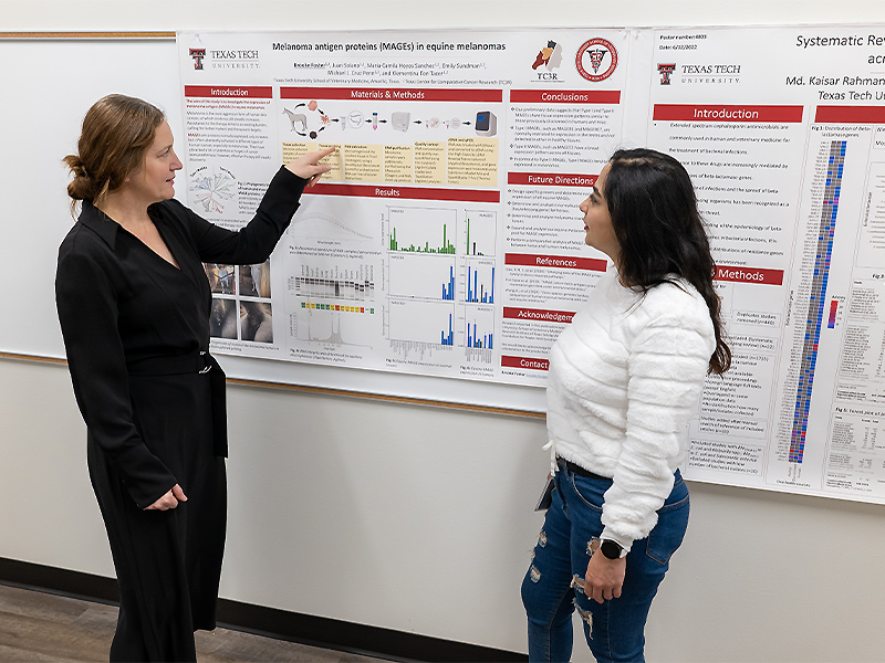 Sima and Klementina looking at a research poster