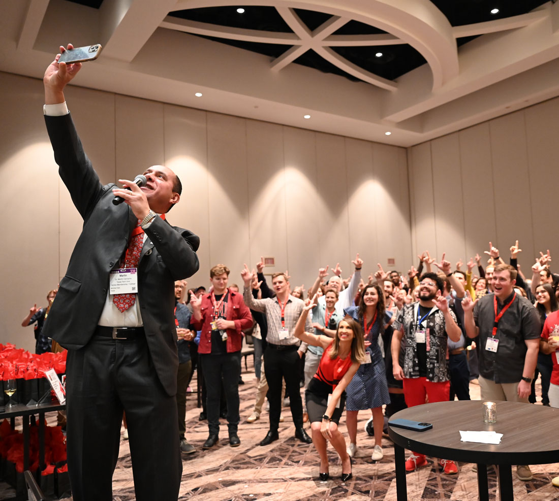 Dean Camacho taking a selfie with a group of students behind him