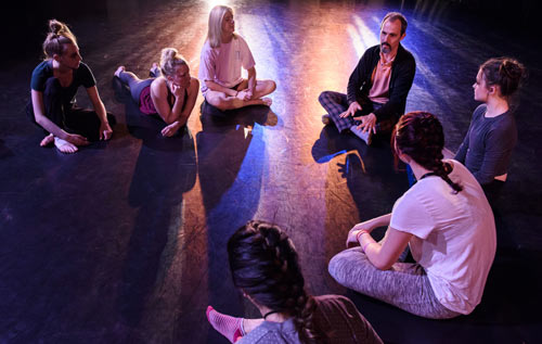 Faculty & dance students sitting on a stage talking