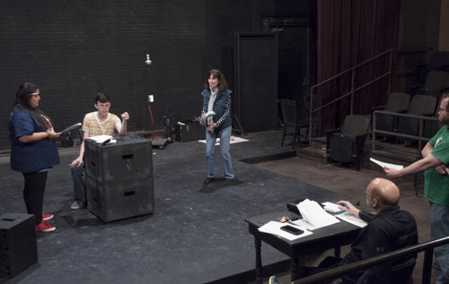 Faculty & students practicing for a play on a stage