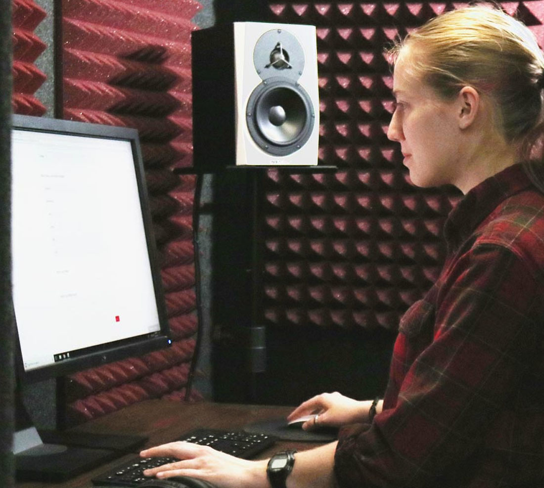 TTU student in sound proof room looking at computer screen